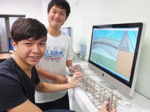 吊り橋の3Dモデルと模型を照らし合わせて検討する学生さん