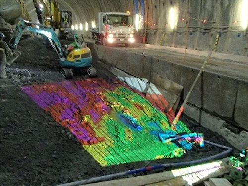プロジェクションマッピングを使って山岳トンネルのインバート掘削管理を行うシステム。設計より高い部分は赤色で表示される（以下の写真、資料：清水建設）