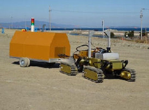 高速道路の建設現場に導入された不整地走行ロボット「健気」。RI試験装置を積んだ台車をけん引している（以下の写真、資料：竹中工務店、竹中土木）