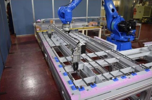 鉄筋自動組み立てシステム「Robotaras」の試作機。ロボットアームの先端部に鉄筋保持治具を取り付け、鉄筋を型枠内に配置しているところ