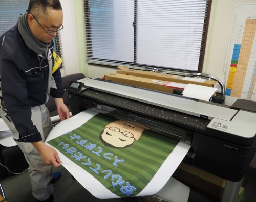 A0プラス対応大判複合機「HP DesignJet T830 MFP」で、現場のオリジナルポスターを印刷する新日本工業の監理技術者、鈴木努氏