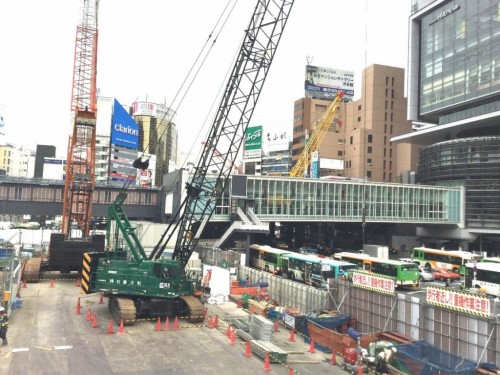 渋谷駅前に建つ渋谷ヒカリエ（右）と通りを隔てて向かい合う東棟の工事現場（左）