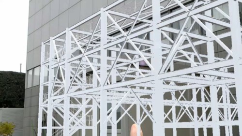 増築工事をイメージした使用例。HoloLensを着用して実物の建物を見る（上）。すると建物の前には鉄骨が実物大で立体的に見える（下）